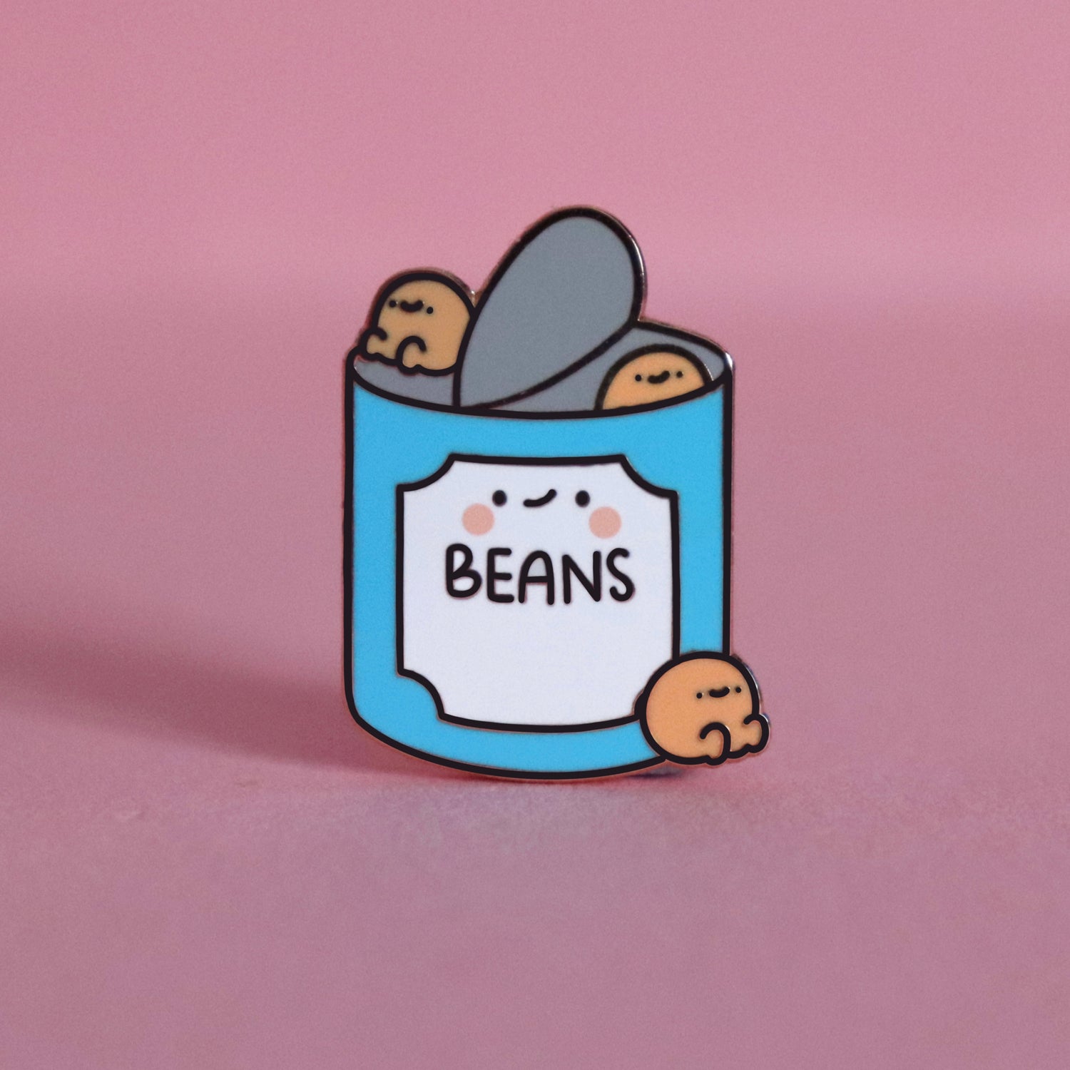 Baked beans enamel pin on pink table