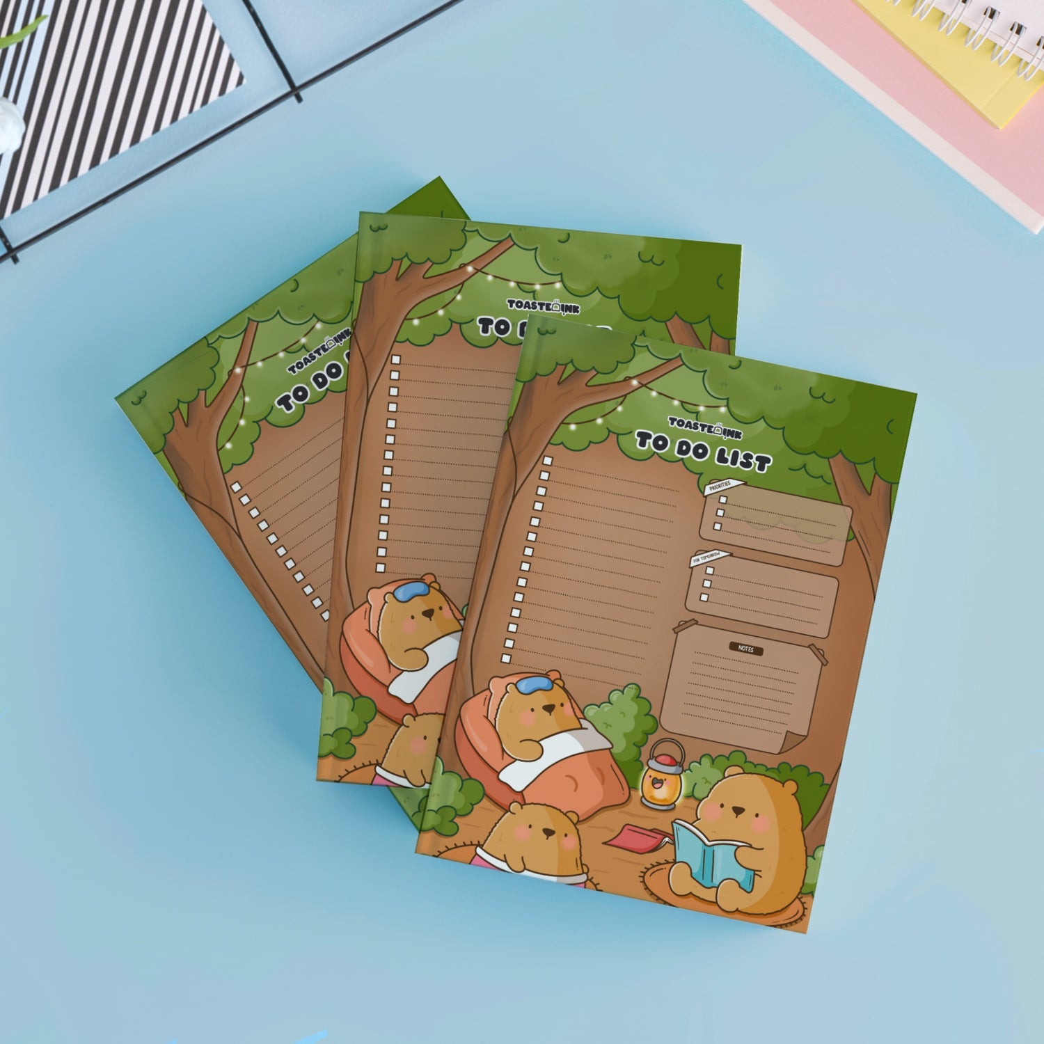 Three to do list bear design notepad on blue table with notebooks