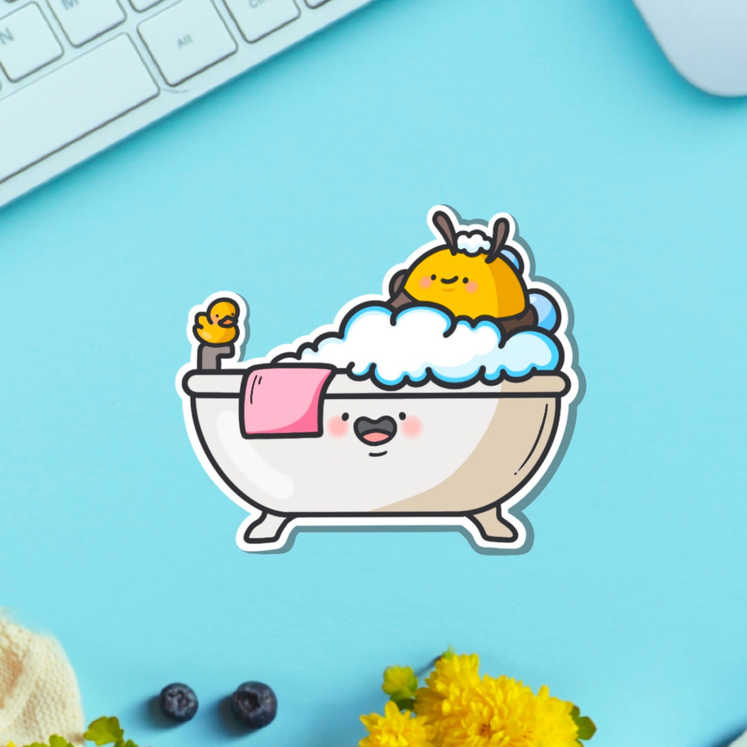 Bee in a bathtub vinyl sticker on blue table with keyboard