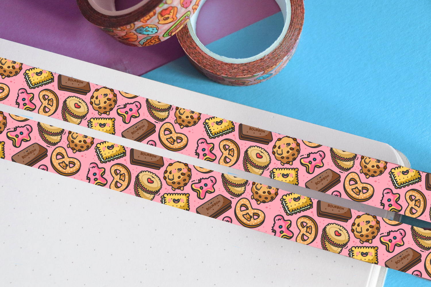 Pink biscuit washi tape on blue and purple table with washi tape rolls