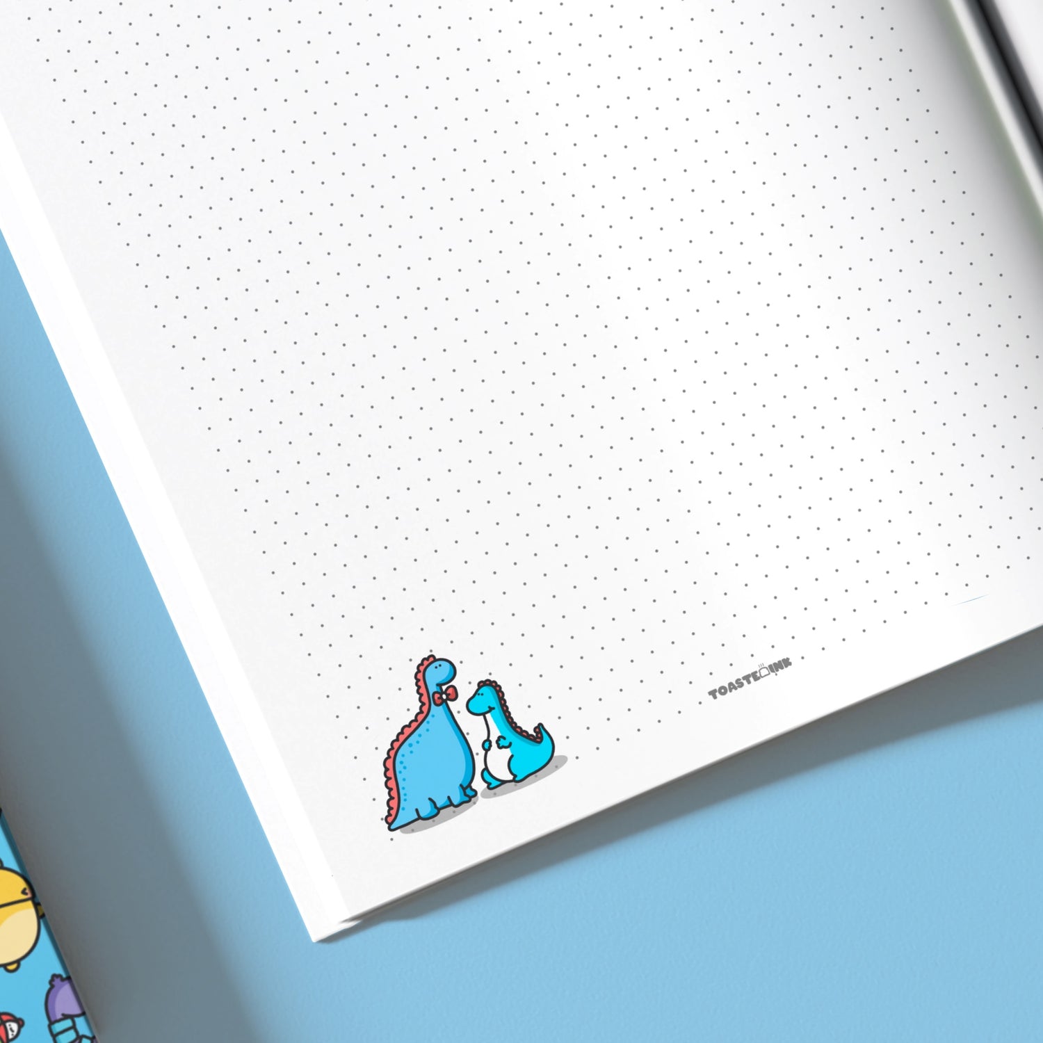 Close up on dinosaurs on dot grid notebook