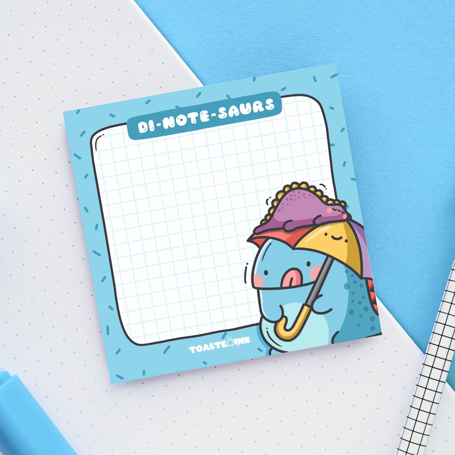 Dinosaur sticky notes on blue and white table