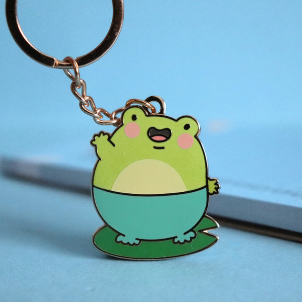 Frog keyring on blue table with notepad