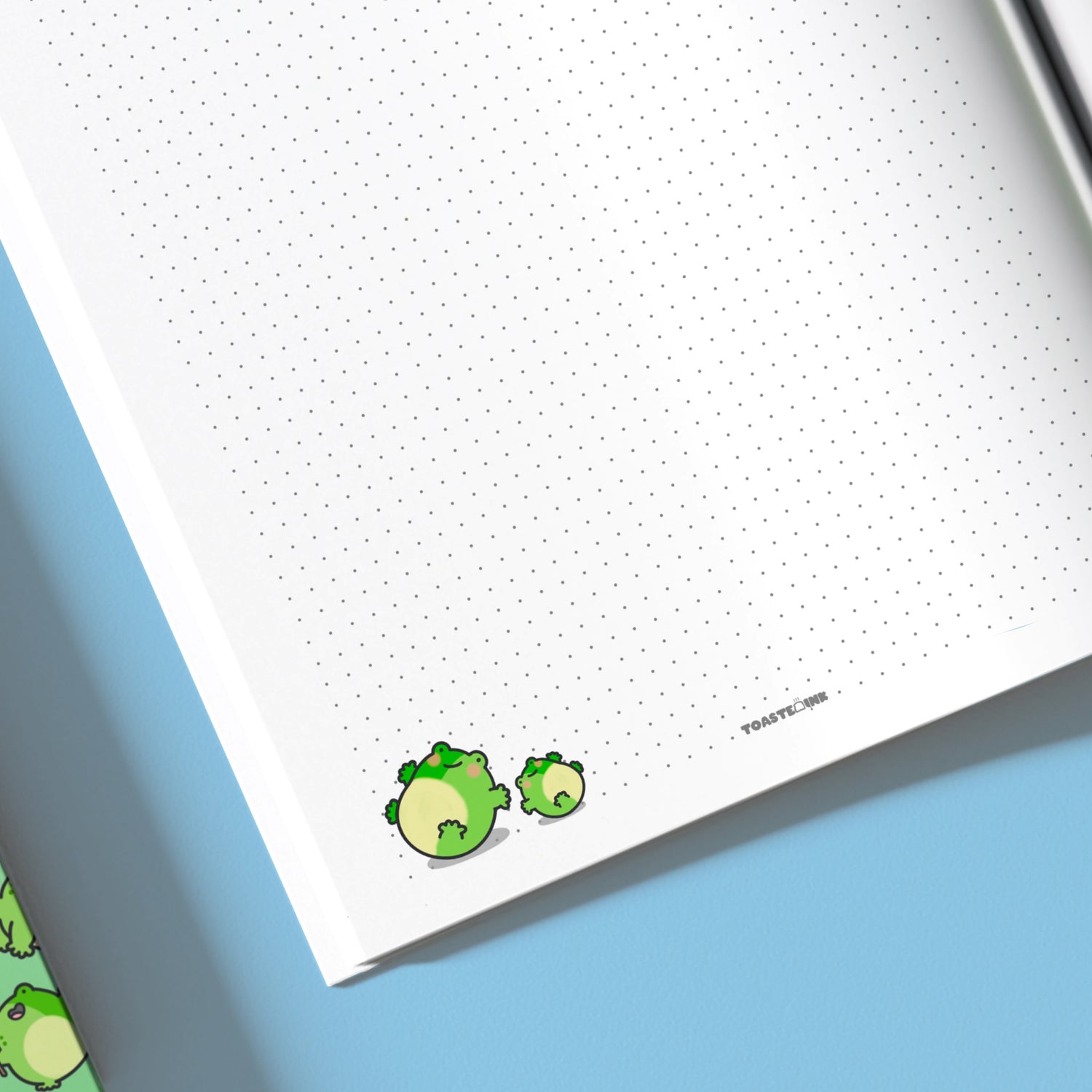 Close up of frogs on dot grid notebook