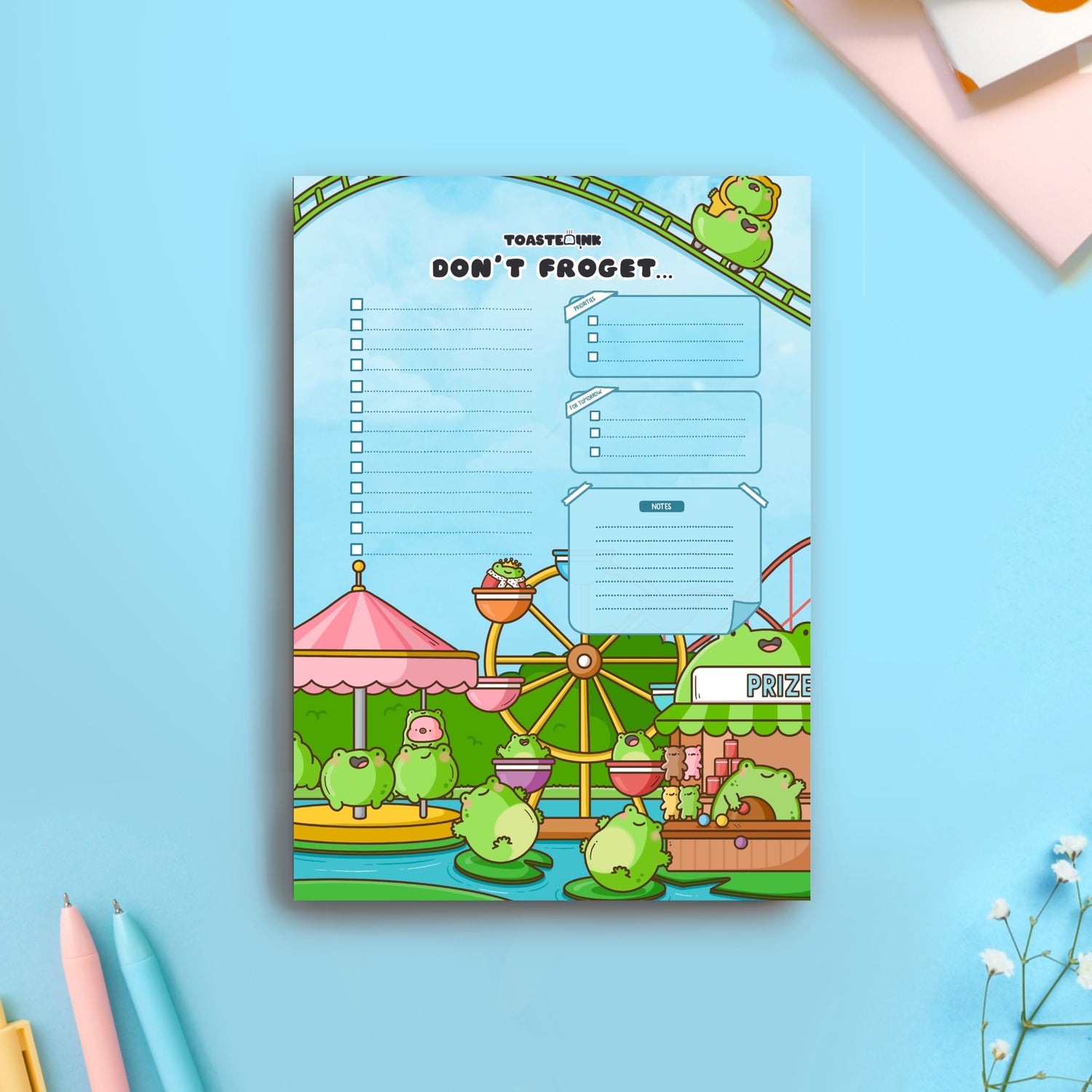 Frog theme park to do list notepad on blue table with notebooks