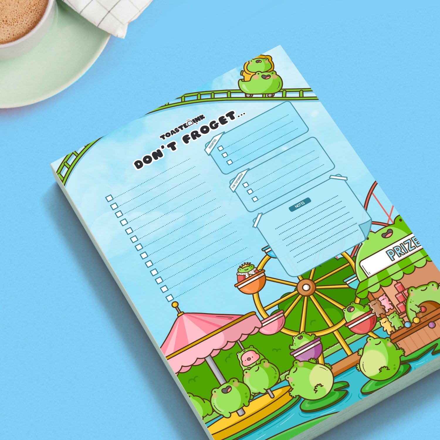 Frog to do list notepad on blue desk with mug of coffee