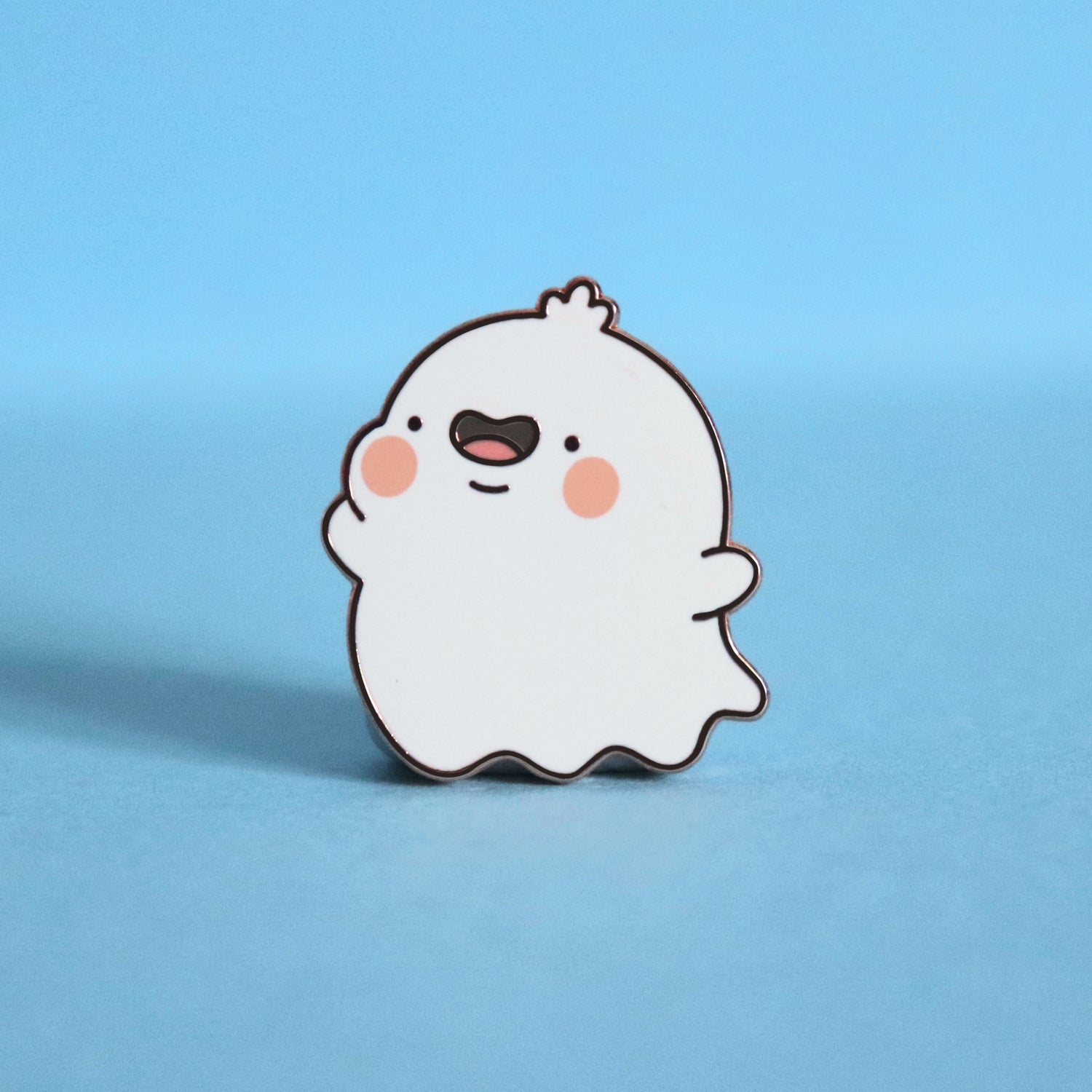 Ghost enamel pin on blue desk