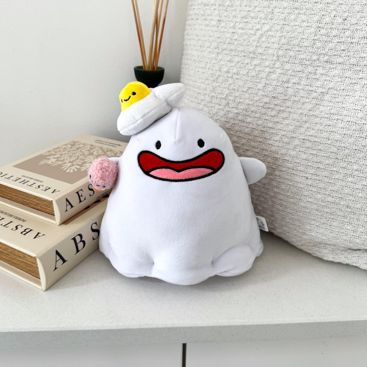 Ghost plush with beige cushion and books