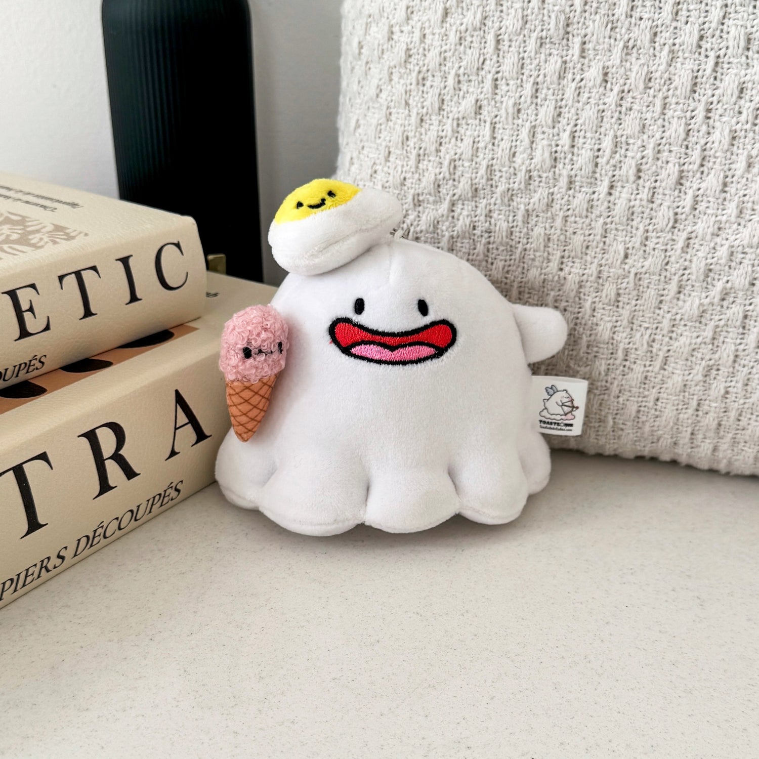 Ghost plush keychain with beige cushion and books