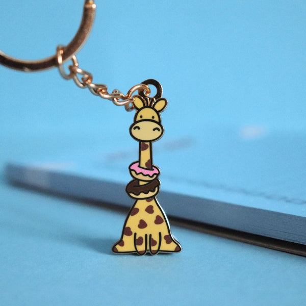 Giraffe with donuts keychain on blue table