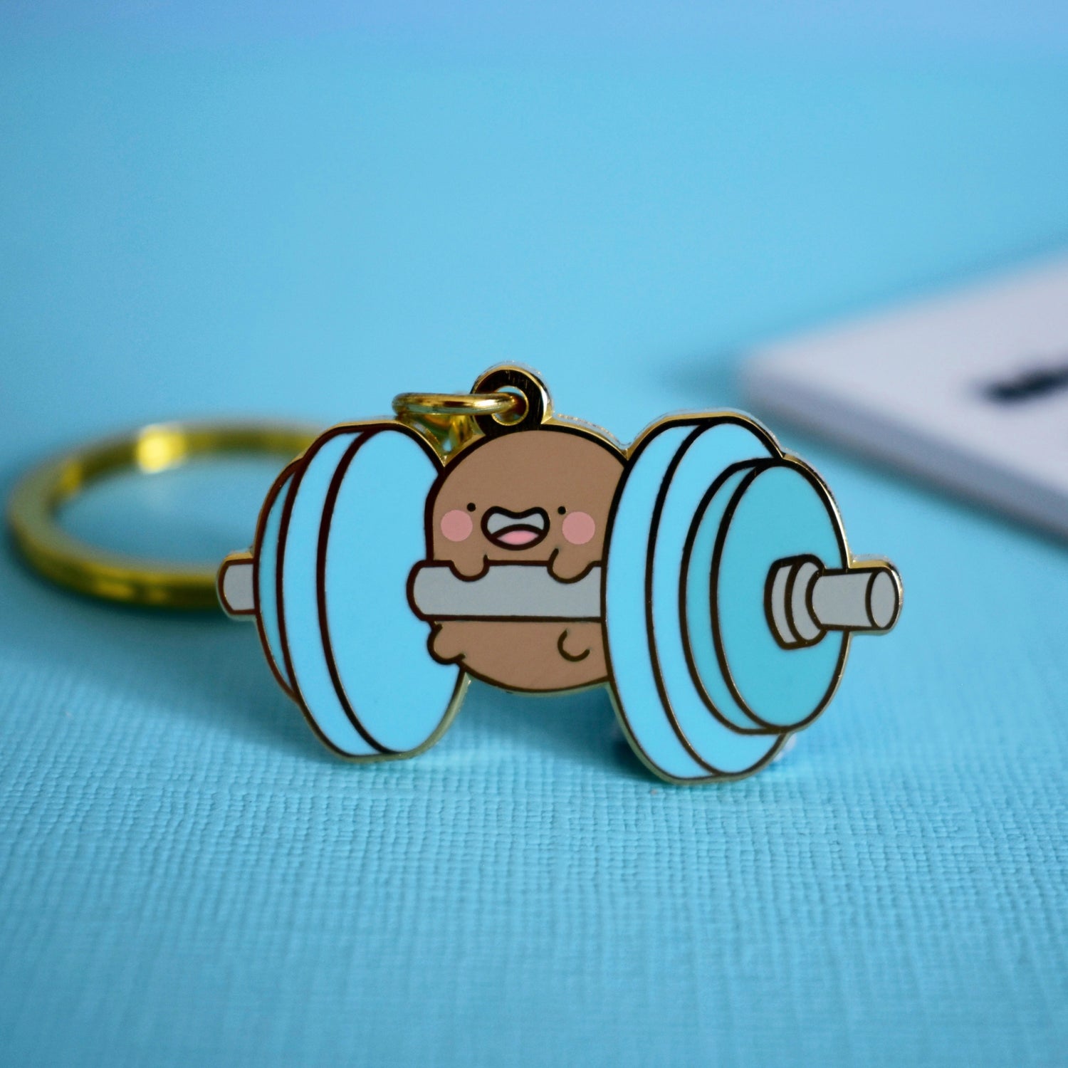 Gym potato keyring on blue table