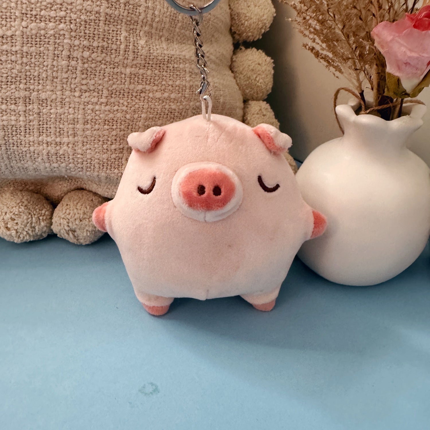 Pig keychain plush on blue table