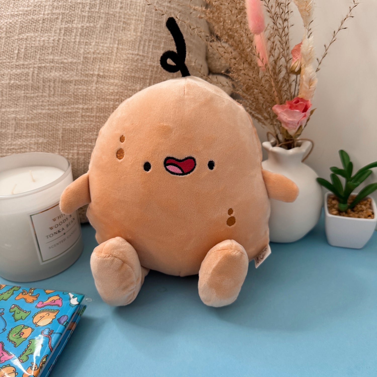 Potato plush with flowers on blue table