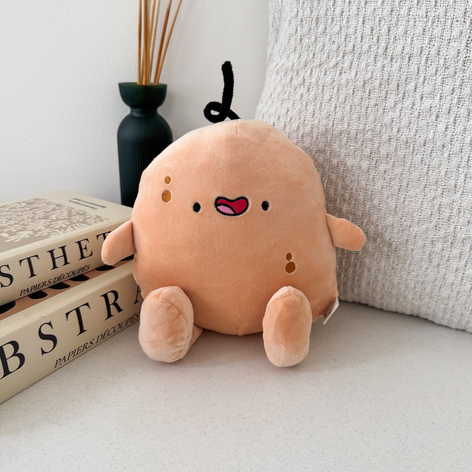 Potato plush with beige cushion and books