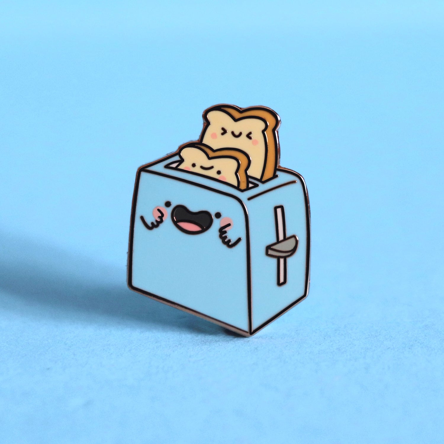 Toaster enamel pin on blue desk