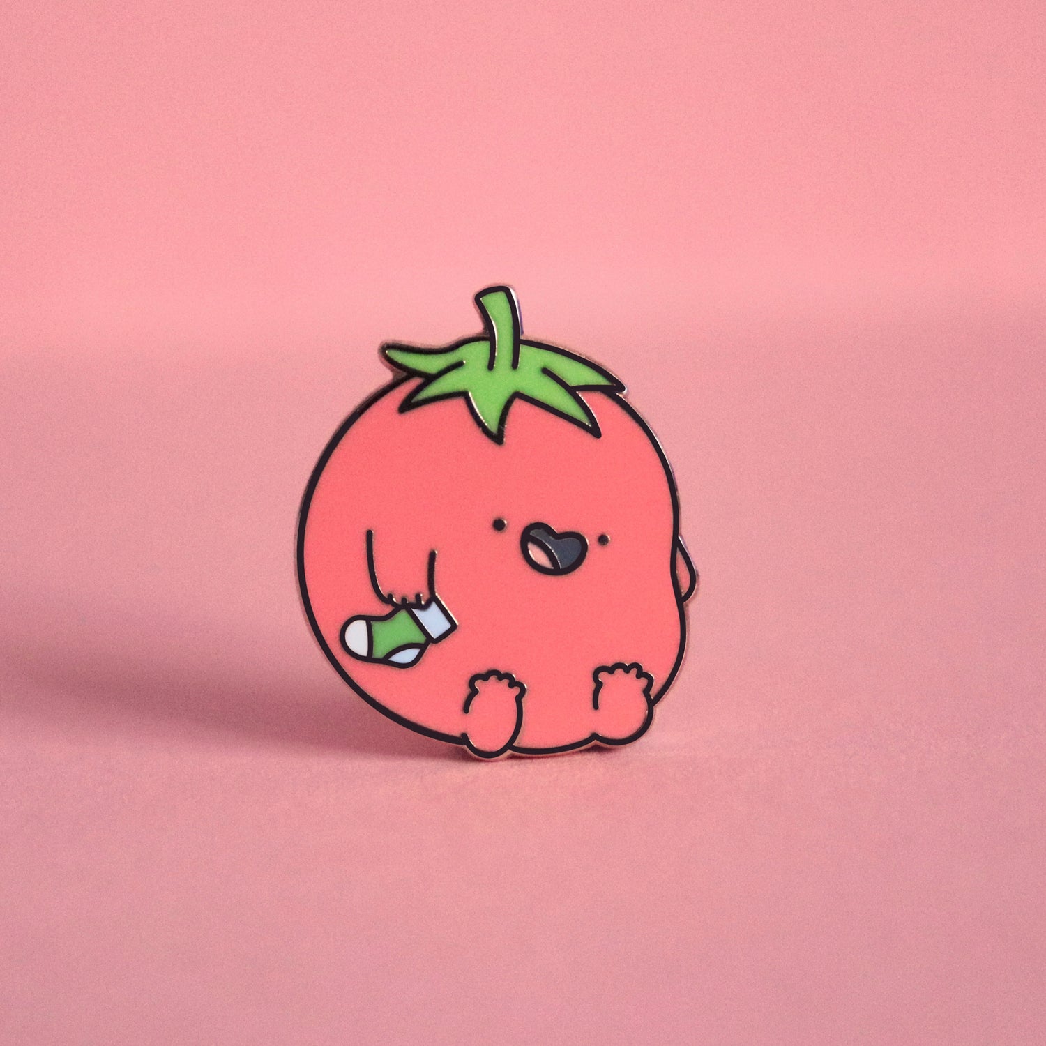 Tomato enamel pin on pink table