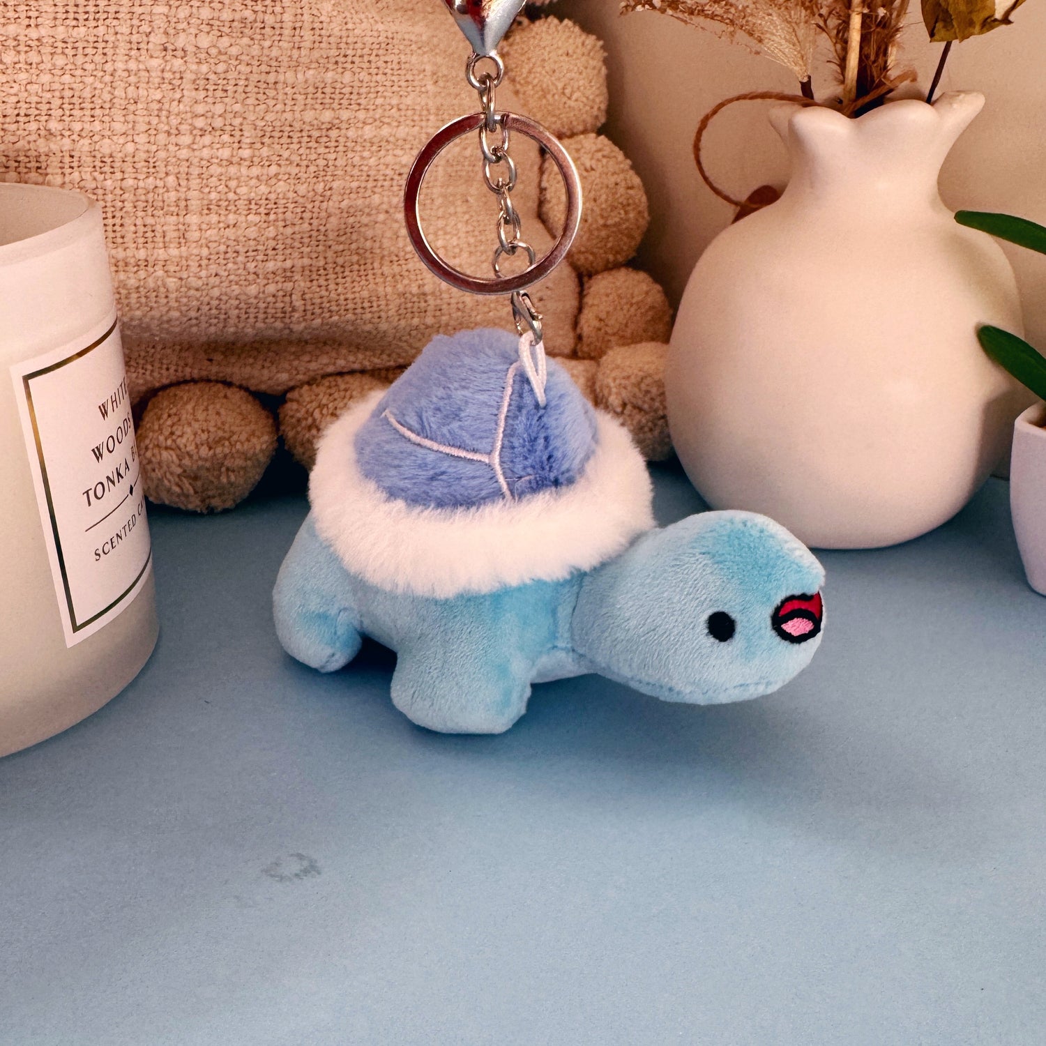 Turtle keychain plush on blue table