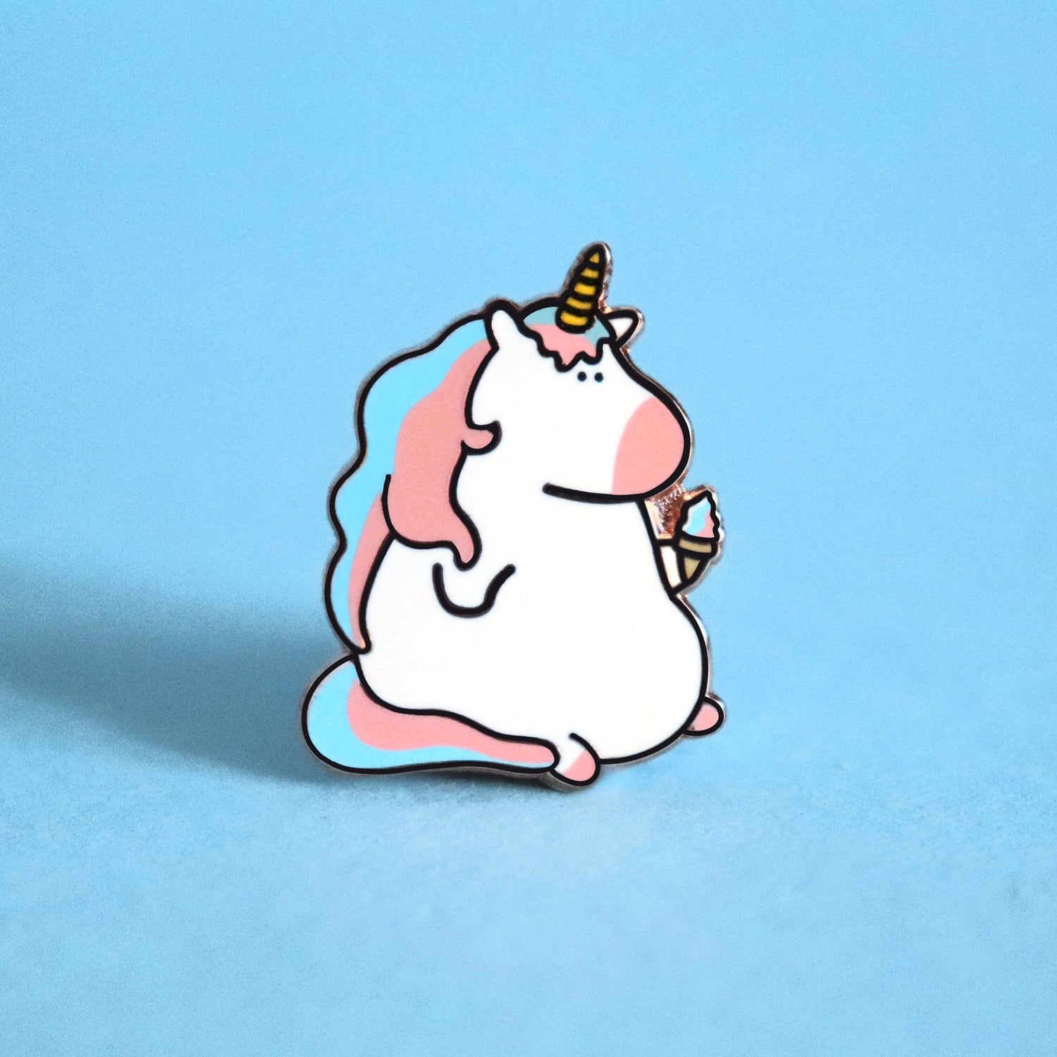 Unicorn enamel pin on blue background