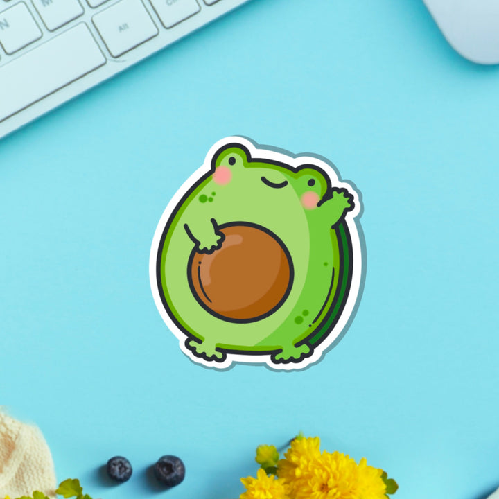 Avocado frog vinyl sticker on blue table with keyboard