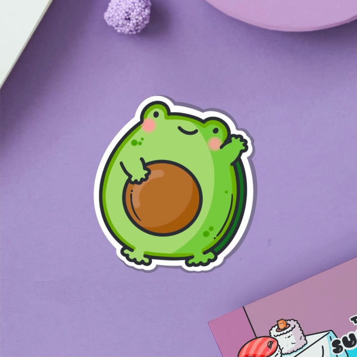 Avocado frog vinyl sticker on purple table