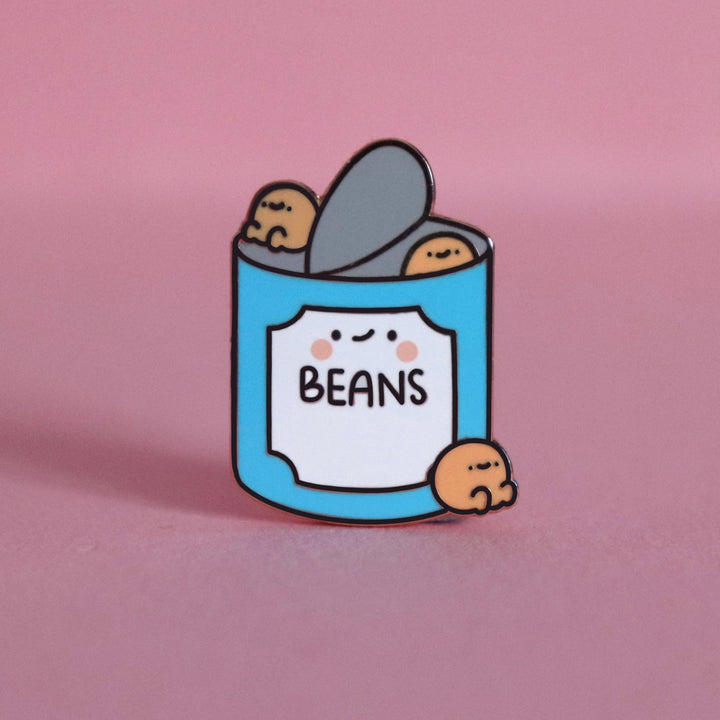 Baked beans enamel pin on pink table