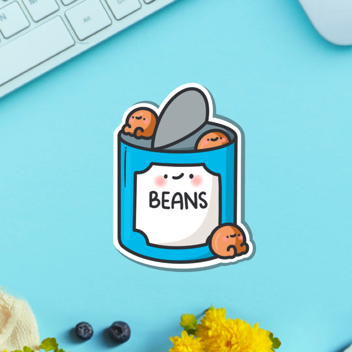 Baked beans vinyl sticker on blue table with keyboard