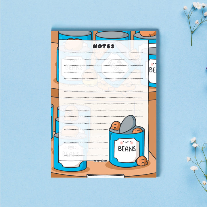 A6 Baked beans notepad on blue table with flowers