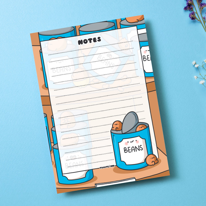 A6 Baked beans notepad on blue desk