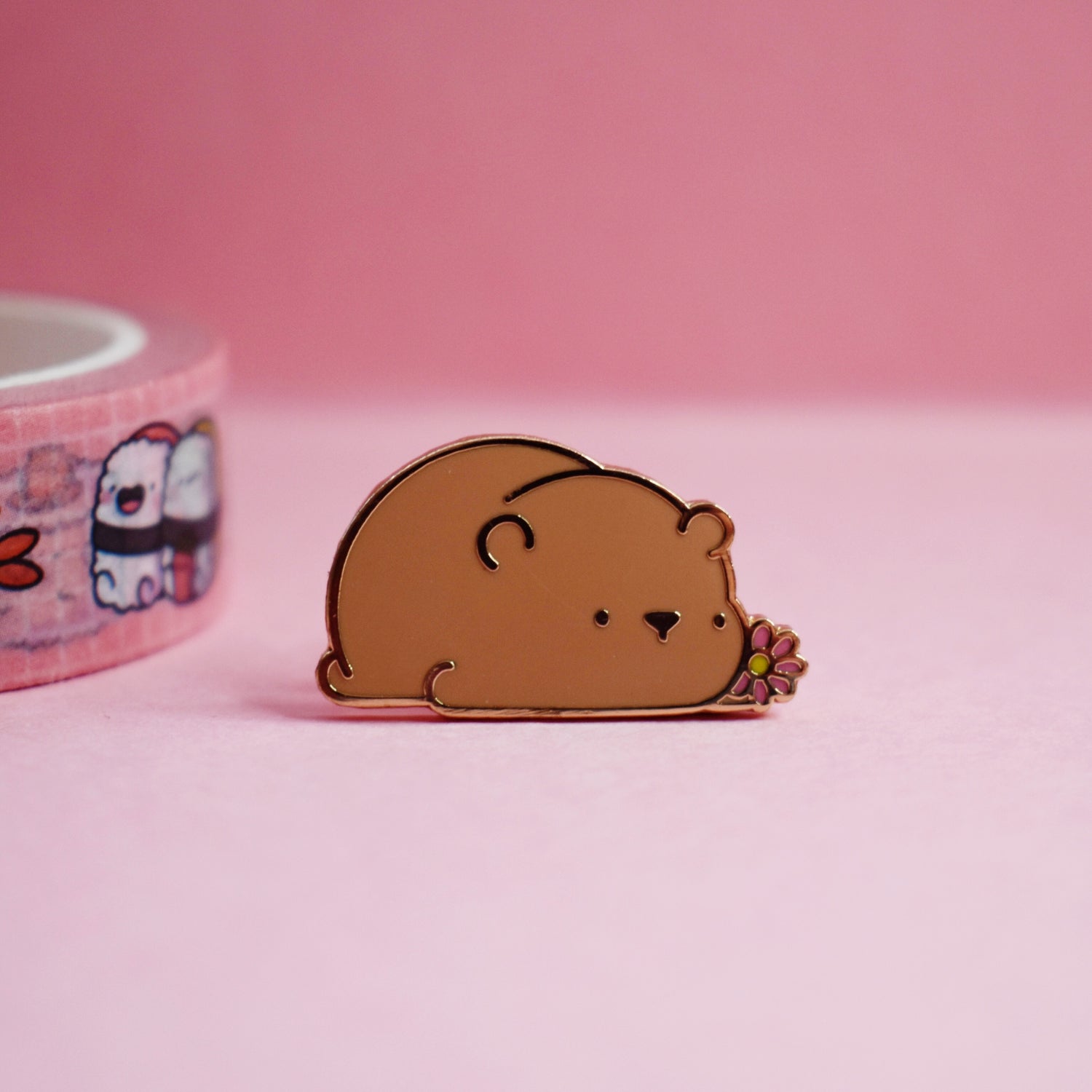 Brown bear enamel pin on pink table