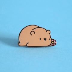 Brown bear enamel pin on blue table