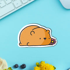 Bear with a flower vinyl sticker on blue table with keyboard