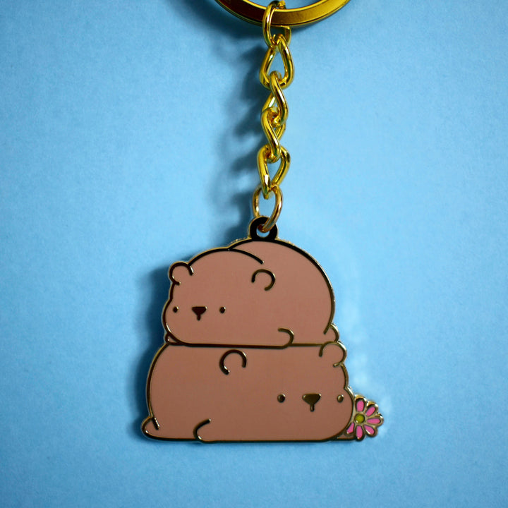 Bear keyring with gold chain on blue table
