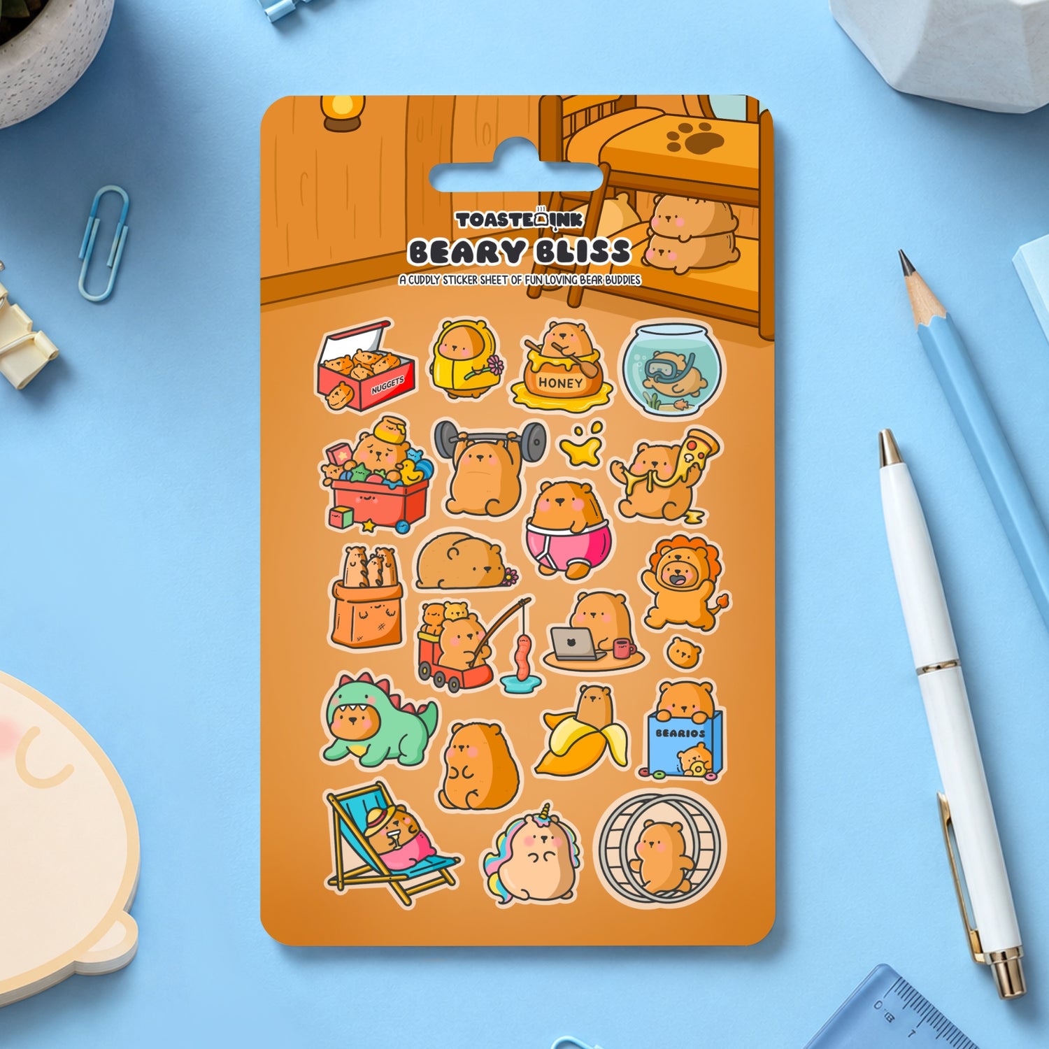 Bear sticker sheet on blue desk with stationery scattered around