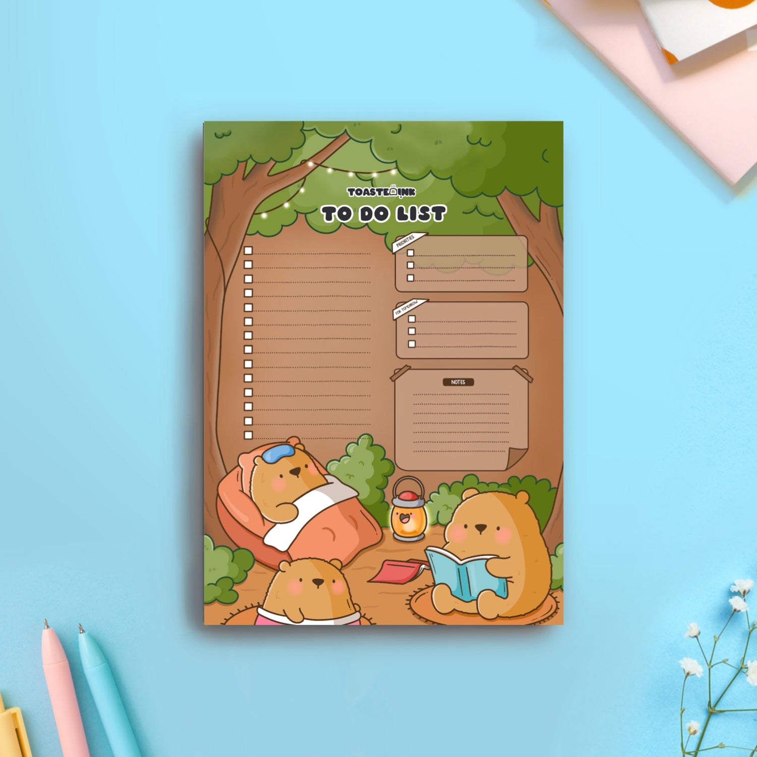 Bear to do list notepad on blue table flat lay with pens and notebooks