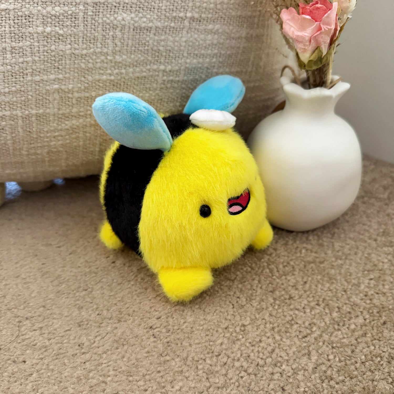 Bee plush keychain on carpet