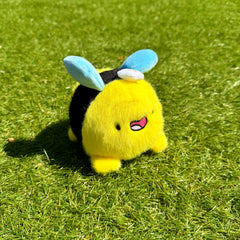 Bee plush keychain on grass
