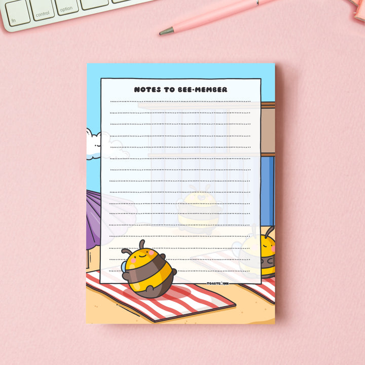 A6 Bee notepad  on pink table with keyboard