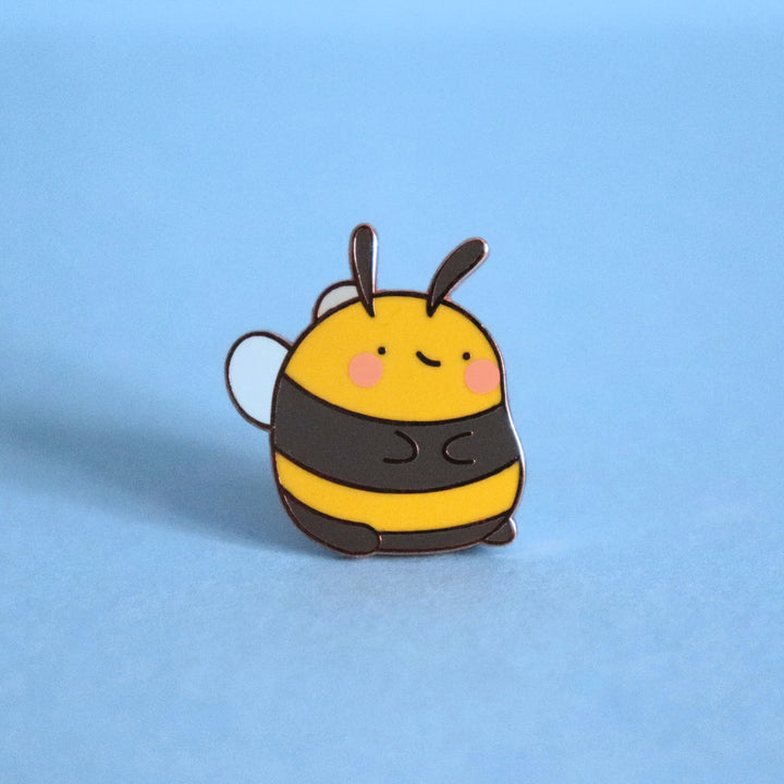 Bee enamel pin on blue background