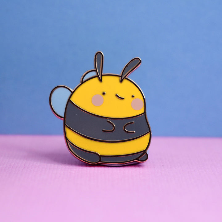 Bee enamel pin on pink and blue background