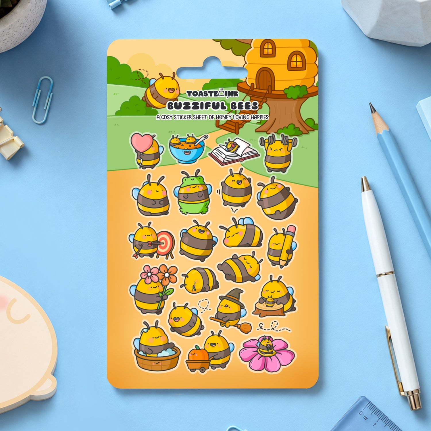 Bumblebee sticker sheet scattered with stationery around on blue table