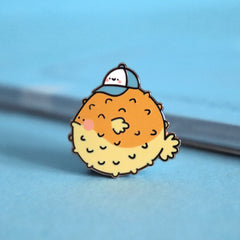 Blowfish enamel pin on blue table