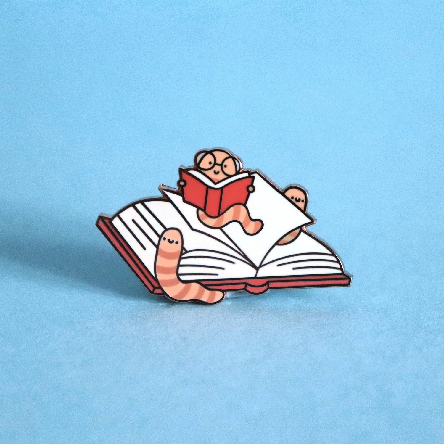 Bookworm enamel pin on blue background
