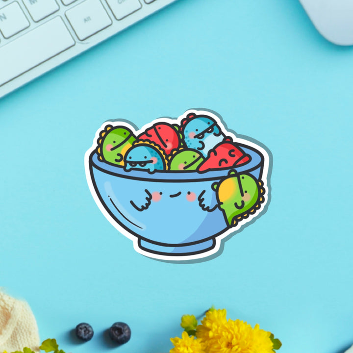 Bowl of dinosaurs vinyl sticker on blue table with keyboard