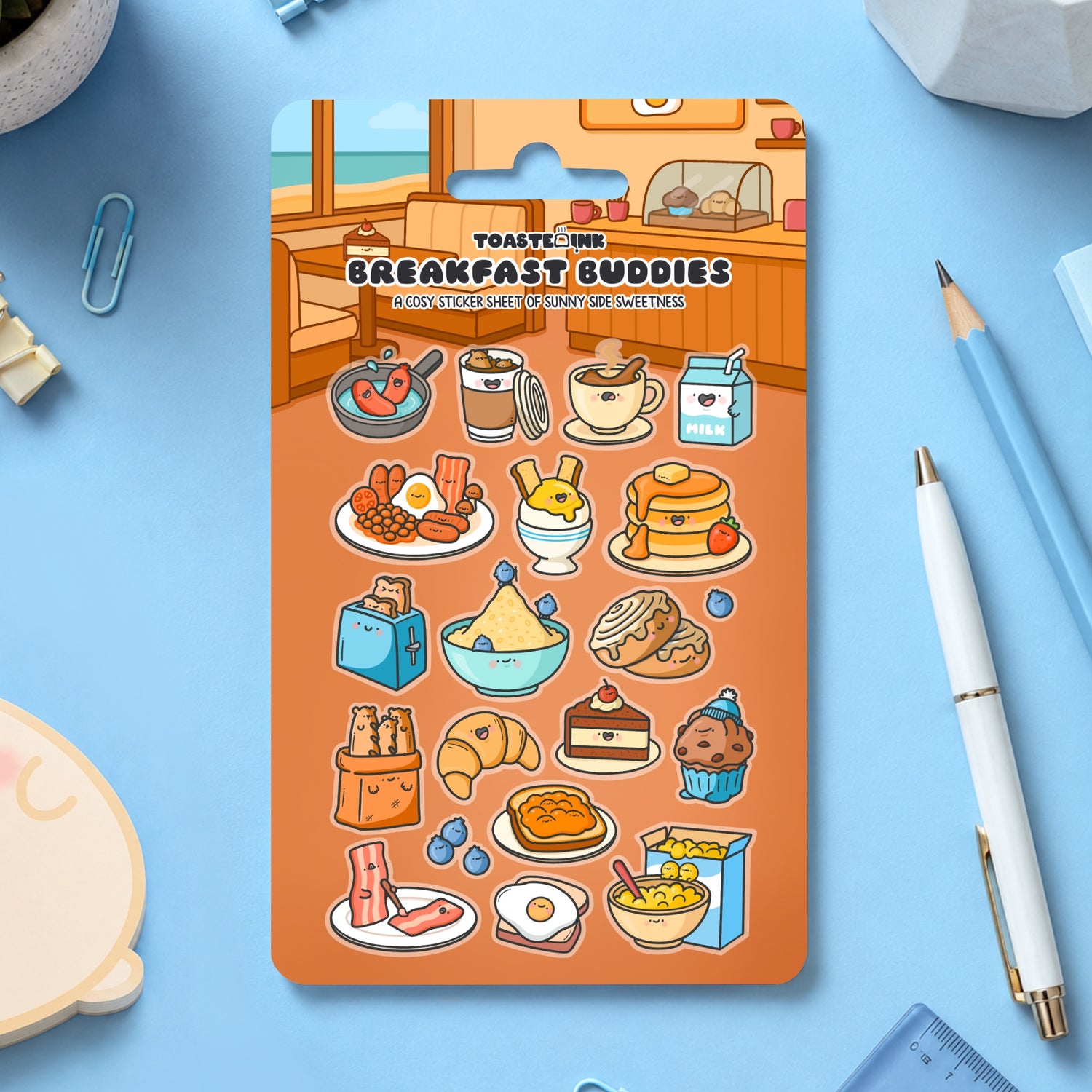 Breakfast sticker sheet with stationery scattered around on blue table