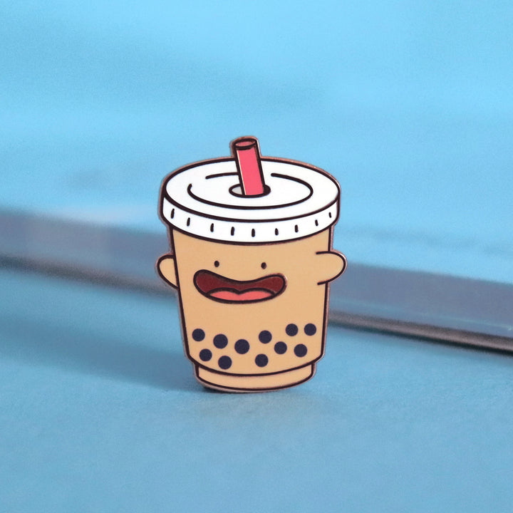 Bubble tea enamel pin on blue table