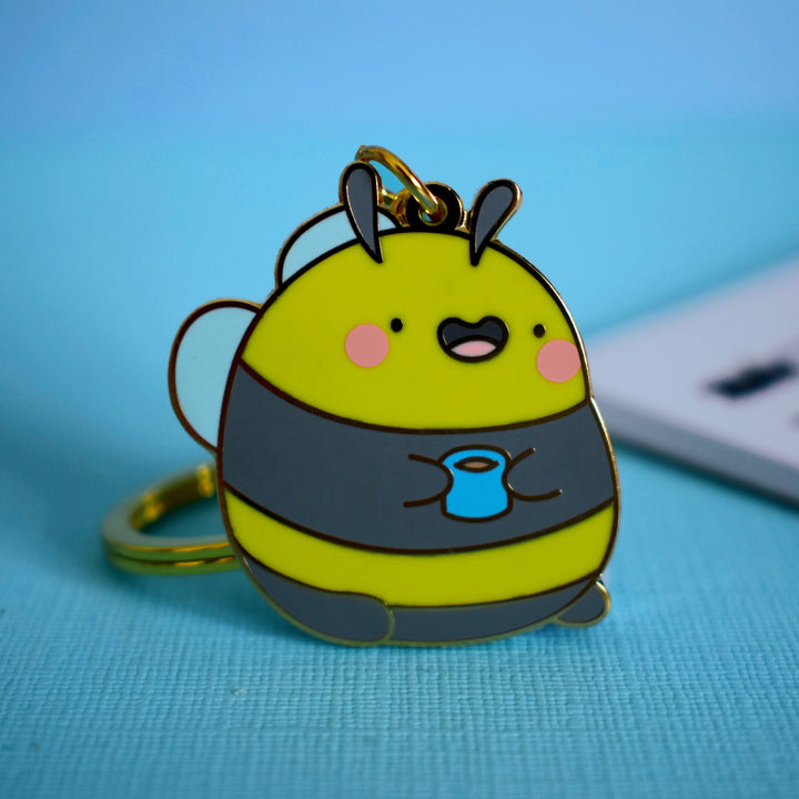 Bumblebee keyring with notebook on blue table