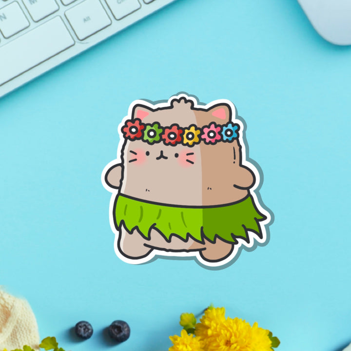 Cat in a grass skirt vinyl sticker on blue table with keyboard