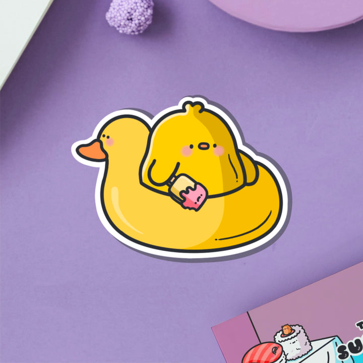 Chick in a rubber duck vinyl sticker on purple table