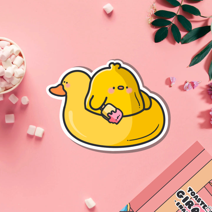 Chick in a rubber duck vinyl sticker on pink table