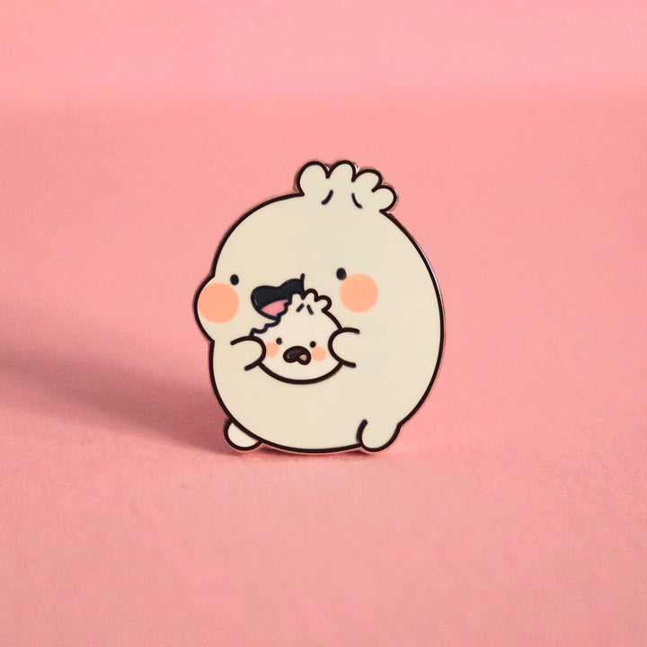 Dumpling eating enamel pin on pink desk